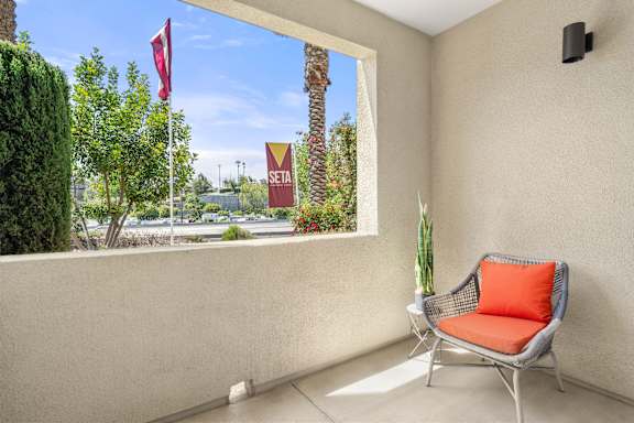 A balcony with a lounge chair.
