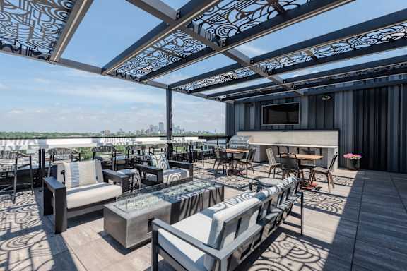 A patio with a table and chairs under a patterned awning.