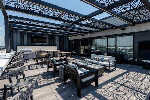 A patio with wooden furniture and a patterned floor.