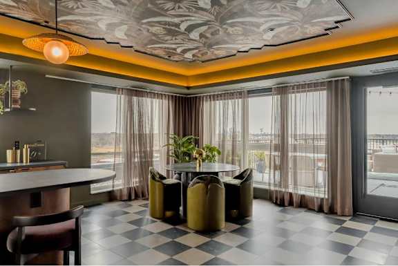 A modern dining room with a checkered floor and a large window.