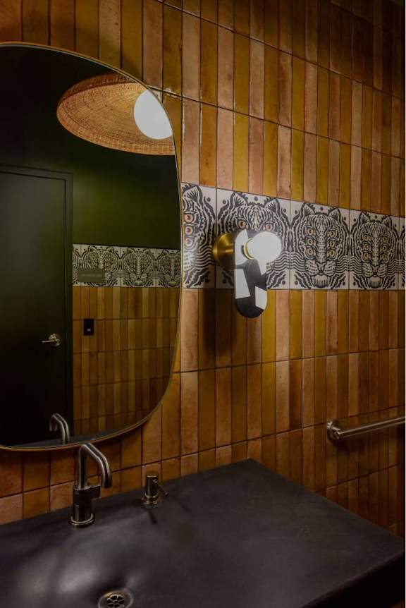 A bathroom with a black sink and a green door.