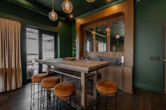 A kitchen with green walls and a wooden island.