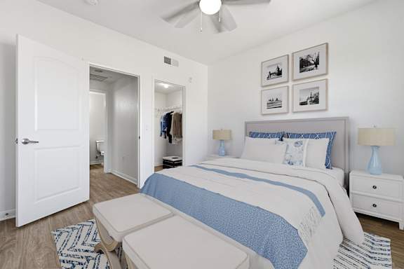 A bedroom with a bed, nightstand, and a ceiling fan.