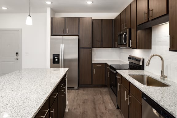 a kitchen with a granite counter top and a stainless steel refrigerator