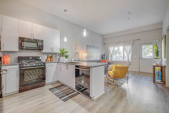A modern kitchen with a white oven and a yellow chair.