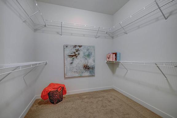 A room with a large painting on the wall and a red object on the floor.