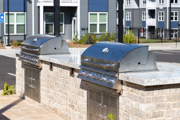 two bbq pits on a brick wall in front of a building
