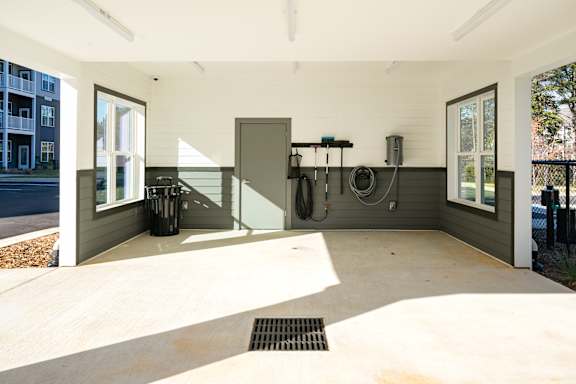 A garage with a concrete floor and a black door.