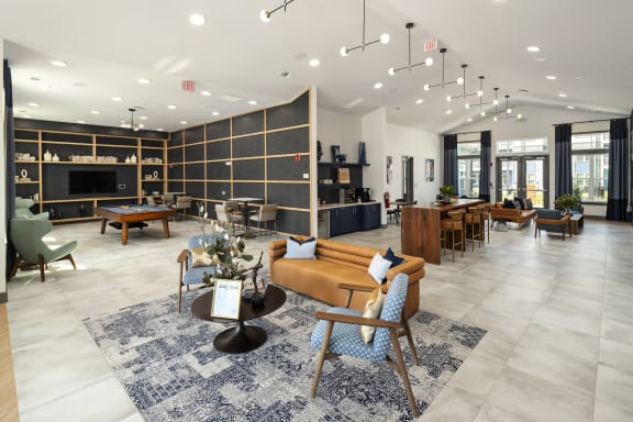 a lobby with couches tables and chairs and a pool table