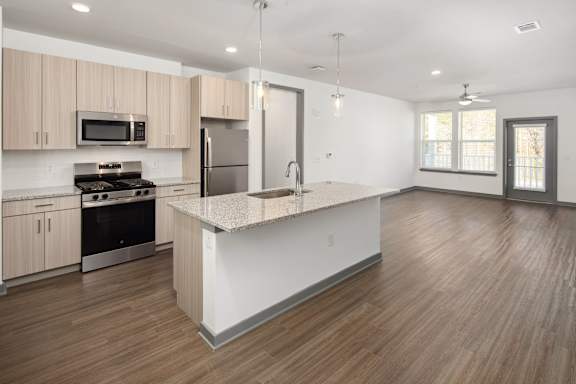 A kitchen with wooden floors and a white island.
