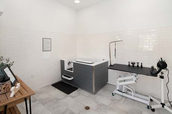 A bathroom with a white tub and a black counter.