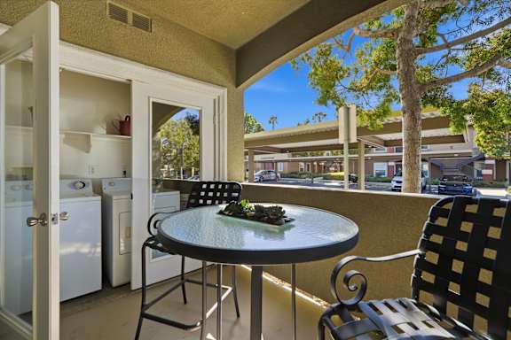 A patio with a table and chairs overlooking a street.