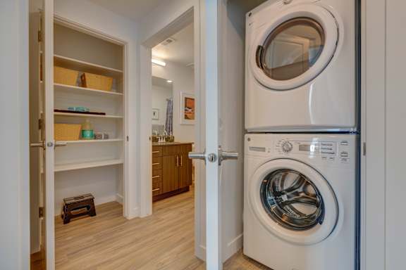 A white washing machine is in a small laundry room.