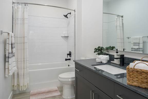 A white toilet sits in a bathroom next to a sink.