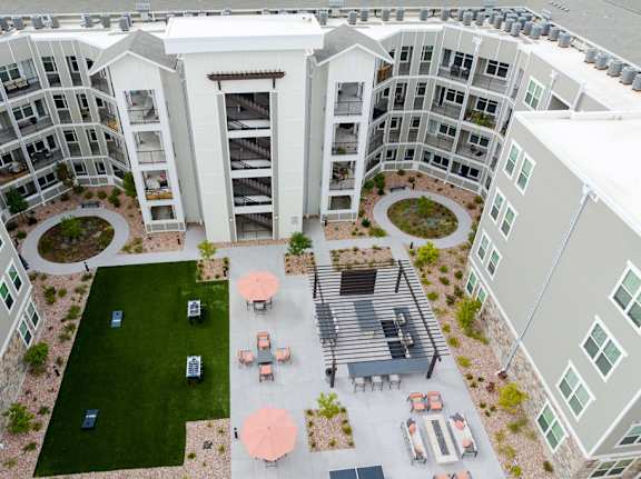 A large white building with a courtyard surrounded by smaller buildings.