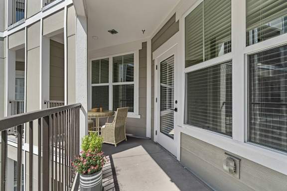 A balcony with a table and chairs.