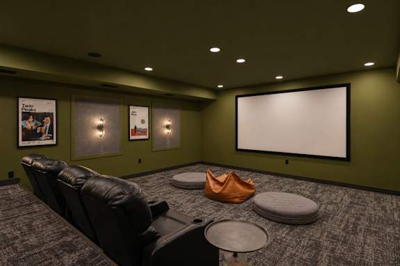 A room with a large screen and a row of seats.