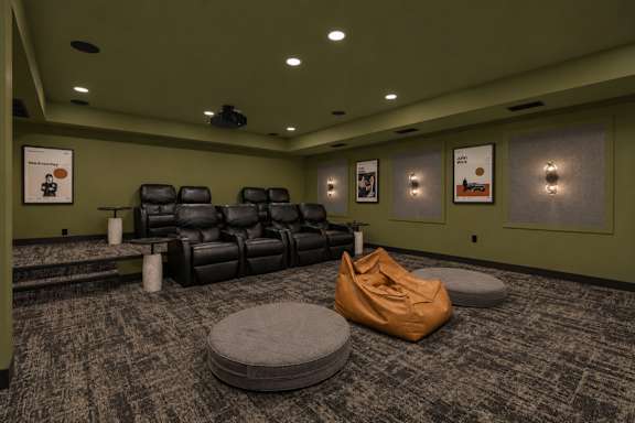A room with a green wall and a carpeted floor with a few chairs and a bean bag.