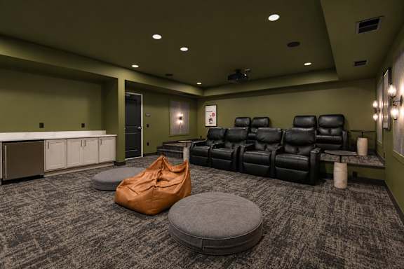 A room with a carpeted floor and a row of black leather chairs.