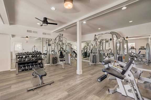 A spacious gym with a variety of equipment including treadmills, weights, and exercise machines.