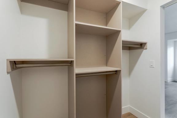 A white wall with a shelf and a doorway.