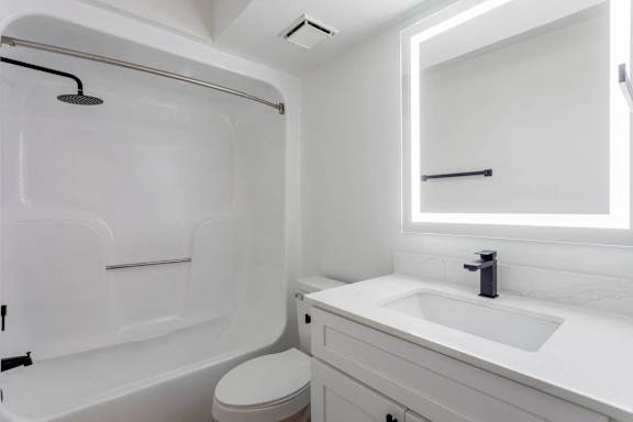 A white bathroom with a toilet, sink, and bathtub.