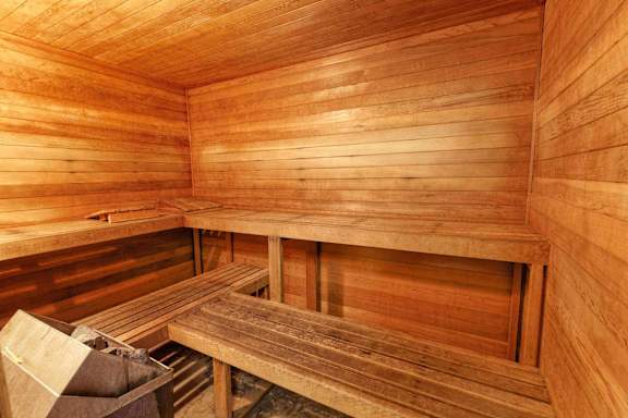 A wooden sauna with benches and a table.