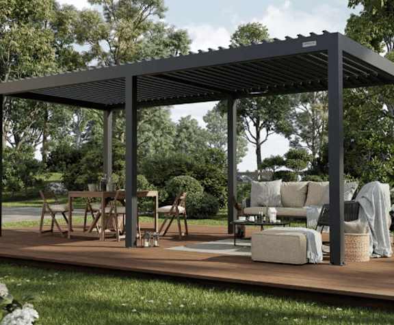 A wooden patio with a black roof and furniture.