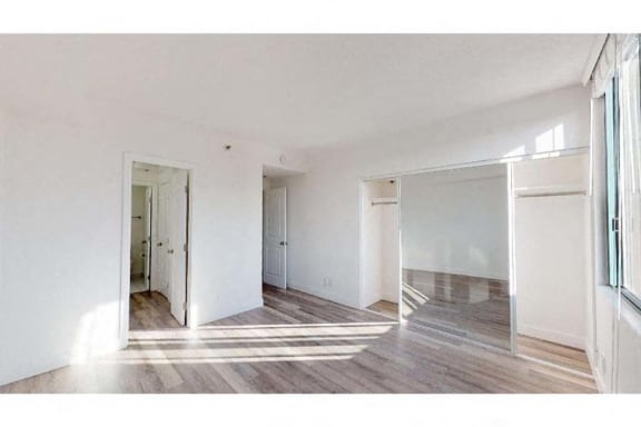 an empty room with white walls and wood floors