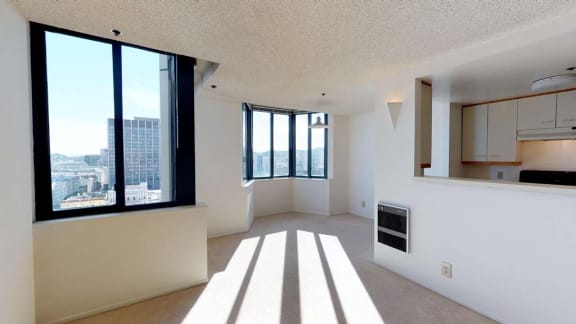 an empty room with a large window and a kitchen