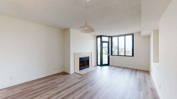 an empty living room with hardwood floors and a fireplace