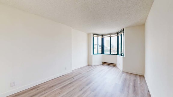 an empty room with hardwood floors and a large window