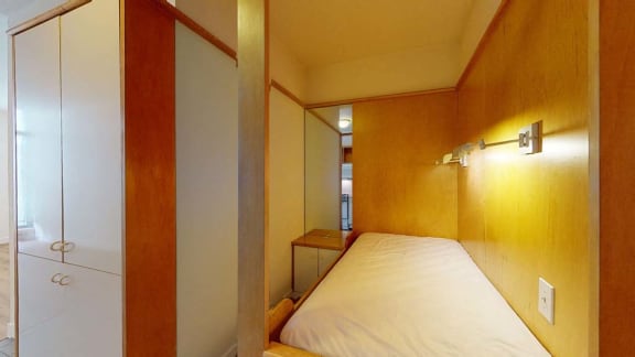 a small room with a bed and a mirror