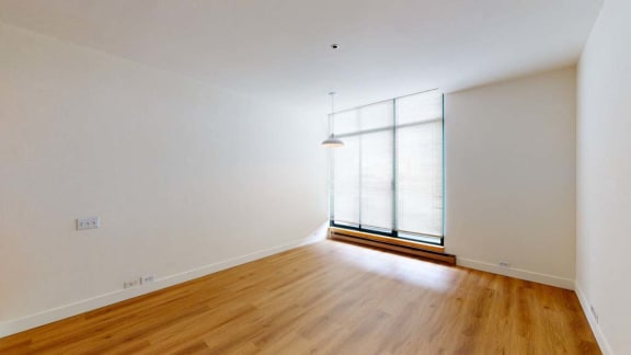 an empty room with white walls and wood floors