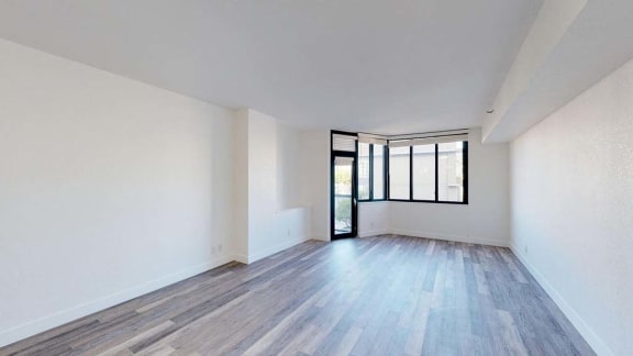 an empty room with white walls and wood floors
