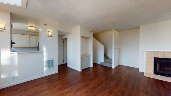 an empty living room with a fireplace and hardwood floors