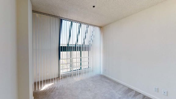 a bedroom with a large window and white walls