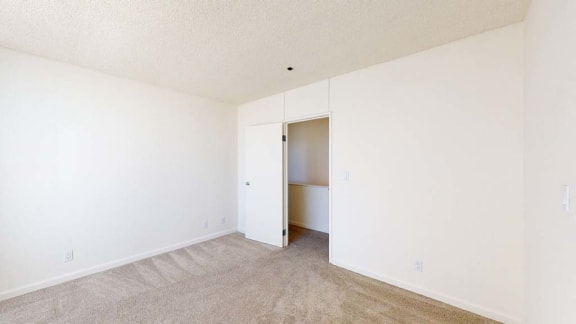 a bedroom with white walls and carpet