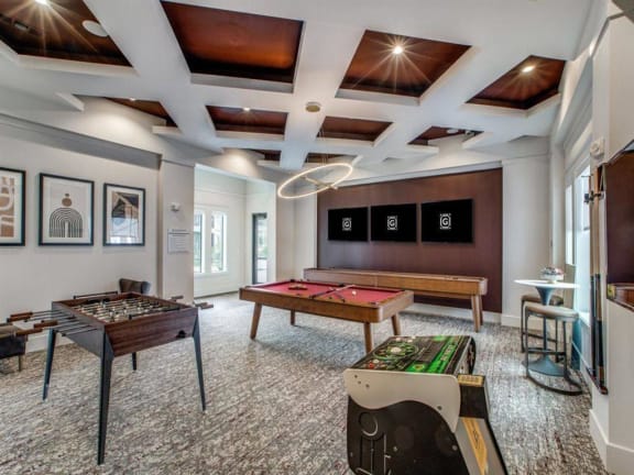 a game room with two pool tables and a television