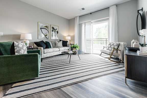 a living room with a large window and a striped rug