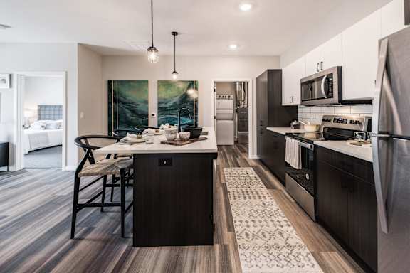 a kitchen and dining area with stainless steel appliances and a table with chairs