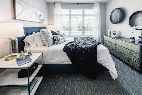 a black and white bedroom with a bed and a window