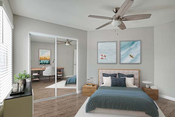 A bedroom with a bed, a desk, a chair, a ceiling fan, and two framed pictures on the wall.