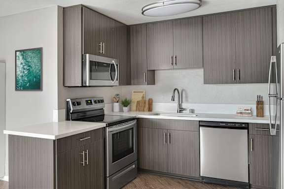 A modern kitchen with a stainless steel dishwasher and a white countertop.