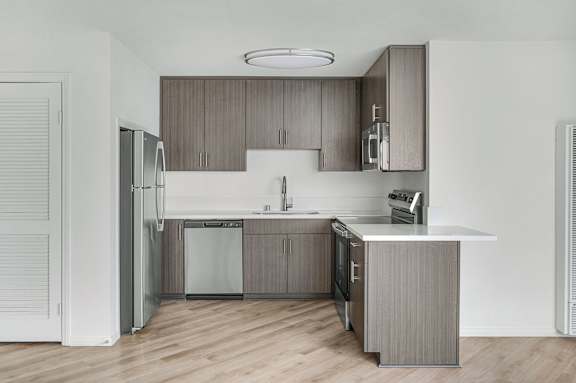A modern kitchen with wooden cabinets and stainless steel appliances.
