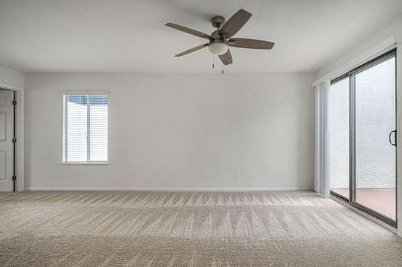 A room with a ceiling fan and a carpeted floor.