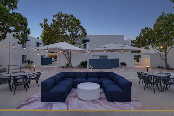 A patio with a white table and blue couches.