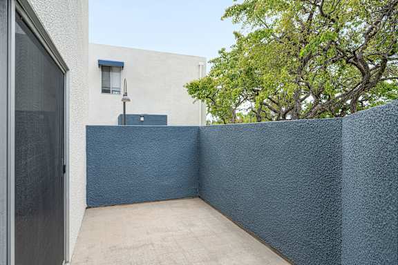 A patio with a blue wall and a door.