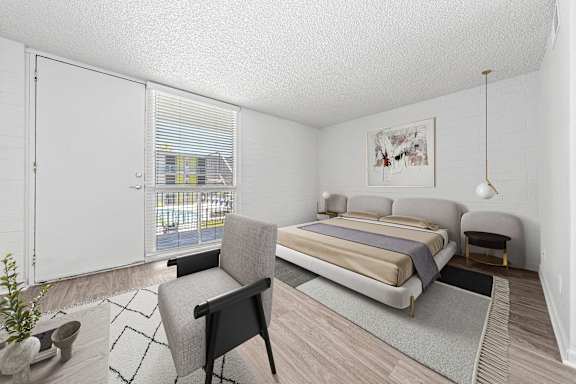 A bedroom with a bed, chair, and a window with blinds.