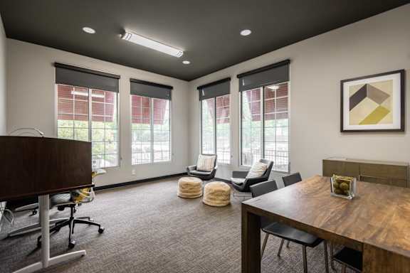 A conference room with a table, chairs, and a framed picture on the wall.
